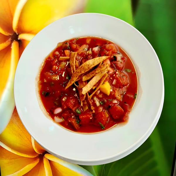 A white bowl filled with red salsa, topped with tortilla strips, against a green and yellow background.